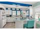 Charming kitchen with white cabinetry, unique blue accents, and modern appliances at 519 Mobile Ave, Daytona Beach, FL 32118