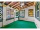Cozy sunroom featuring natural wood ceiling beams and a green carpet at 519 Mobile Ave, Daytona Beach, FL 32118