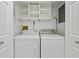 Laundry area with white washer and dryer, and overhead storage shelves at 520 S Peninsula Ave # 2C7, New Smyrna Beach, FL 32169