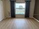 Bright bedroom featuring neutral walls, a large window with curtains, and wood-look flooring, providing a tranquil retreat at 533 Marina Point Dr # 533, Daytona Beach, FL 32114