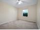 This bedroom offers neutral walls, carpet flooring, and a ceiling fan at 549 Coral Trace Blvd, Edgewater, FL 32132