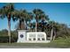 Coral Trace community entrance sign surrounded by lush green landscaping and mature palm trees at 549 Coral Trace Blvd, Edgewater, FL 32132