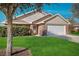 Charming one-story home featuring a well-manicured lawn, a brick facade, and a two-car garage at 549 Coral Trace Blvd, Edgewater, FL 32132