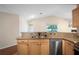 Kitchen featuring granite countertops, stainless steel appliances, light wood cabinets, and tile floors at 549 Coral Trace Blvd, Edgewater, FL 32132