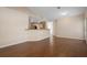 Open-concept living room with wood floors and view into kitchen at 549 Coral Trace Blvd, Edgewater, FL 32132