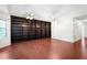 Spacious living room with hardwood floors, a ceiling fan, and a wall of built-in bookshelves at 549 Coral Trace Blvd, Edgewater, FL 32132