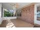 Covered porch with exposed brick and a view into a screened-in area at 549 Coral Trace Blvd, Edgewater, FL 32132