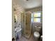 Bathroom featuring a shower stall, toilet, sink, and decorative wallpaper at 630 Yupon Ave, New Smyrna Beach, FL 32169