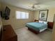 Comfortable bedroom featuring a ceiling fan and large window bringing in plenty of light at 630 Yupon Ave, New Smyrna Beach, FL 32169