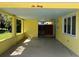 Brightly painted yellow car port provides ample covered parking and protection from the elements at 630 Yupon Ave, New Smyrna Beach, FL 32169