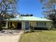 Charming yellow home with a green metal roof, well-maintained lawn, and blue trim accents at 630 Yupon Ave, New Smyrna Beach, FL 32169