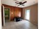 Living room with tiled floor, wood paneled wall, and glass door with plenty of natural light at 630 Yupon Ave, New Smyrna Beach, FL 32169