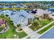 An aerial view of a single-story home with a lake view, landscaped yard, and screened lanai with pool at 6665 Merryvale Ln, Port Orange, FL 32128