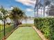 Fenced backyard with manicured artificial grass, complemented by lush landscaping and views of a peaceful lake at 6665 Merryvale Ln, Port Orange, FL 32128