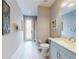 Neutral-toned bathroom boasts a modern vanity with marble countertop, a toilet, and shower with decorative accents at 6665 Merryvale Ln, Port Orange, FL 32128