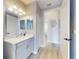 Stylish bathroom featuring a vanity with marble countertop, and a decorative mirror with modern lighting fixtures at 6665 Merryvale Ln, Port Orange, FL 32128