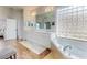 Bathroom featuring double vanity, soaking tub with glass block window, and separate tiled shower at 6665 Merryvale Ln, Port Orange, FL 32128