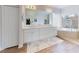 The primary bathroom features a double vanity, soaking tub, and a separate glass enclosed shower with a neutral color palette at 6665 Merryvale Ln, Port Orange, FL 32128