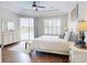 Bedroom with tray ceiling, ceiling fan, wood floors, shuttered windows, and glass door access to the pool at 6665 Merryvale Ln, Port Orange, FL 32128