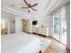Bedroom featuring a tray ceiling, ceiling fan, and access to a private patio with sliding glass doors at 6665 Merryvale Ln, Port Orange, FL 32128