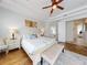 Bright bedroom boasts tray ceilings, ceiling fan, wood floors, and ensuite bathroom and walk-in closet access at 6665 Merryvale Ln, Port Orange, FL 32128