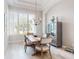 Bright dining room area with chandelier, large windows and white plantation shutters at 6665 Merryvale Ln, Port Orange, FL 32128