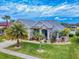 Beautiful single-story home featuring mature palms, landscaping, manicured lawn and a paver driveway at 6665 Merryvale Ln, Port Orange, FL 32128