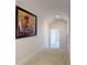 Hallway with neutral carpet, bright white walls, and tasteful artwork at 6665 Merryvale Ln, Port Orange, FL 32128