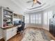 Home office with built-in shelving, a ceiling fan, and beautiful wood floors at 6665 Merryvale Ln, Port Orange, FL 32128