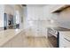 Well-lit kitchen featuring modern appliances, white cabinetry, and a spacious center island with stone countertops at 6665 Merryvale Ln, Port Orange, FL 32128