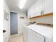 Functional laundry room with updated appliances, white cabinets for storage, and modern lighting at 6665 Merryvale Ln, Port Orange, FL 32128