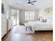 Bright main bedroom featuring tray ceilings, hardwood floors, and access to the pool at 6665 Merryvale Ln, Port Orange, FL 32128
