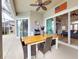 Covered patio featuring an outdoor dining table, ceiling fan, grill, and sliding glass doors to the home's interior at 6665 Merryvale Ln, Port Orange, FL 32128