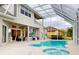 Spacious backyard with a screened pool, spa, and patio seating, ideal for outdoor activities and relaxation at 6665 Merryvale Ln, Port Orange, FL 32128