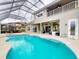 Backyard with a screened pool, spa, and patio seating, perfect for enjoying the outdoors and entertaining guests at 6665 Merryvale Ln, Port Orange, FL 32128