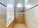 Tiled shower features a shower head, two shelves, and a glass enclosure with a towel bar at 6665 Merryvale Ln, Port Orange, FL 32128