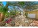 Lush backyard featuring rock ground cover, mature trees, stepping stones, and a small deck at 72 Oceanview Ave, Ponce Inlet, FL 32127