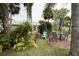 Backyard oasis with patio seating, mature palm trees, and views of a peaceful pond, perfect for relaxation at 731 Pine Shores Cir, New Smyrna Beach, FL 32168