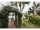 Patio with outdoor seating beneath a vine-covered arch, set against a scenic backdrop of a tranquil pond and lush greenery at 731 Pine Shores Cir, New Smyrna Beach, FL 32168