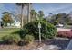 Neighborhood sign surrounded by lush landscaping and mature trees near a home and parked car at 731 Pine Shores Cir, New Smyrna Beach, FL 32168