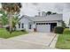 Charming single-story home features an attached garage, landscaped front yard, and mature palm trees enhancing curb appeal at 731 Pine Shores Cir, New Smyrna Beach, FL 32168