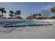 Large community pool surrounded by palm trees, lounge chairs, and privacy fence at 731 Pine Shores Cir, New Smyrna Beach, FL 32168