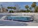 Community pool surrounded by palm trees, lounge chairs, and a white fence at 731 Pine Shores Cir, New Smyrna Beach, FL 32168