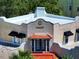 Unique architecture with stucco exterior, red tile details, and black awnings add character to this building's design at 746 N Halifax Ave, Daytona Beach, FL 32118