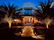 Beautiful home at dusk with landscape lighting, a red tile roof, and a welcoming walkway framed by palm trees at 746 N Halifax Ave, Daytona Beach, FL 32118