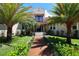 Charming Mediterranean-style home with a vibrant green lawn, beautiful palm trees, and a welcoming walkway at 746 N Halifax Ave, Daytona Beach, FL 32118