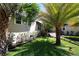 Home exterior with tropical landscaping, including palms and lawn at 746 N Halifax Ave, Daytona Beach, FL 32118