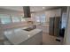 Bright kitchen features white cabinets, stainless steel appliances and large center island with quartz countertop at 746 N Halifax Ave, Daytona Beach, FL 32118