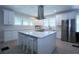 Bright kitchen features white cabinets, stainless steel appliances and large center island with seating at 746 N Halifax Ave, Daytona Beach, FL 32118