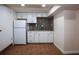 Compact kitchen with white cabinets, granite countertops, and a tile backsplash at 746 N Halifax Ave, Daytona Beach, FL 32118